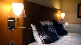 Nattlampe og pute, detaljer i standard rom ved Clarion Collection Hotel Kompaniet Nyköping