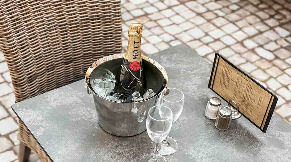 Restaurant med bord og stoler med champagne og menu ved Clarion Collection Hotel Victoria Jönköping 