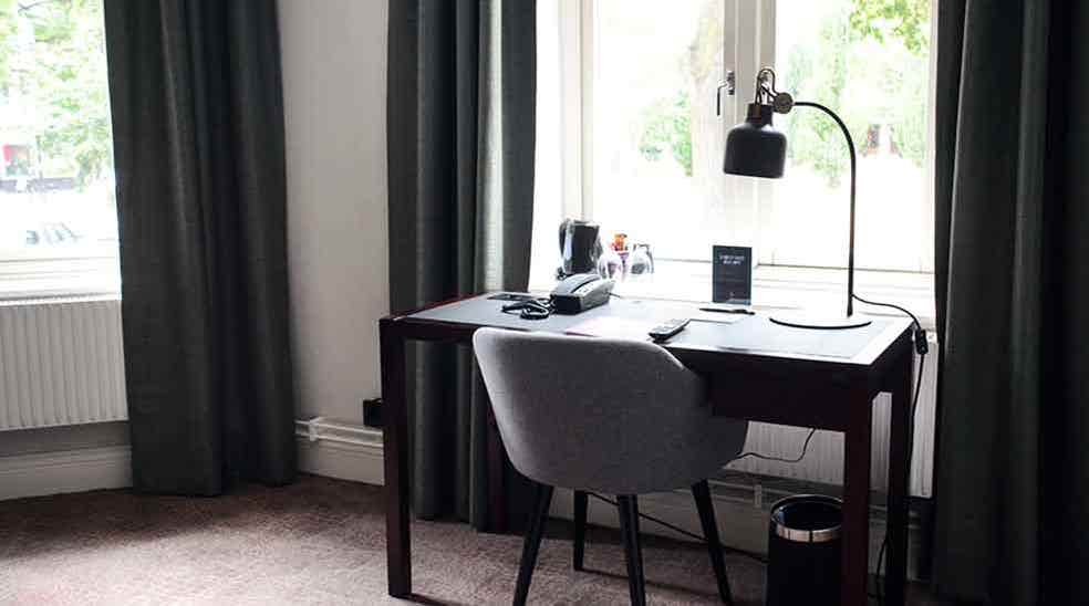 Suite med skrivebord foran vinduet ved Clarion Collection Hotel Victoria Jönköping