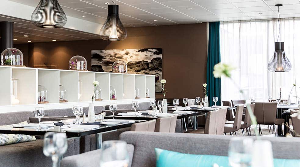Spiseområde med sofa, stoler og pådekket bord med vinglass i restauranten ved Quality Airport Hotel Værnes