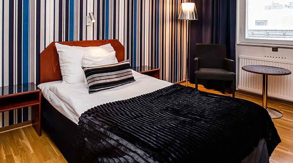 Moderate rom med seng og stripete tapet på Quality Hotel Statt i Hudiksvall